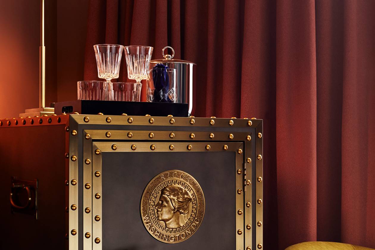 A vintage vault in an elegantly designed room showcases a minibar with drinks and clean glasses.